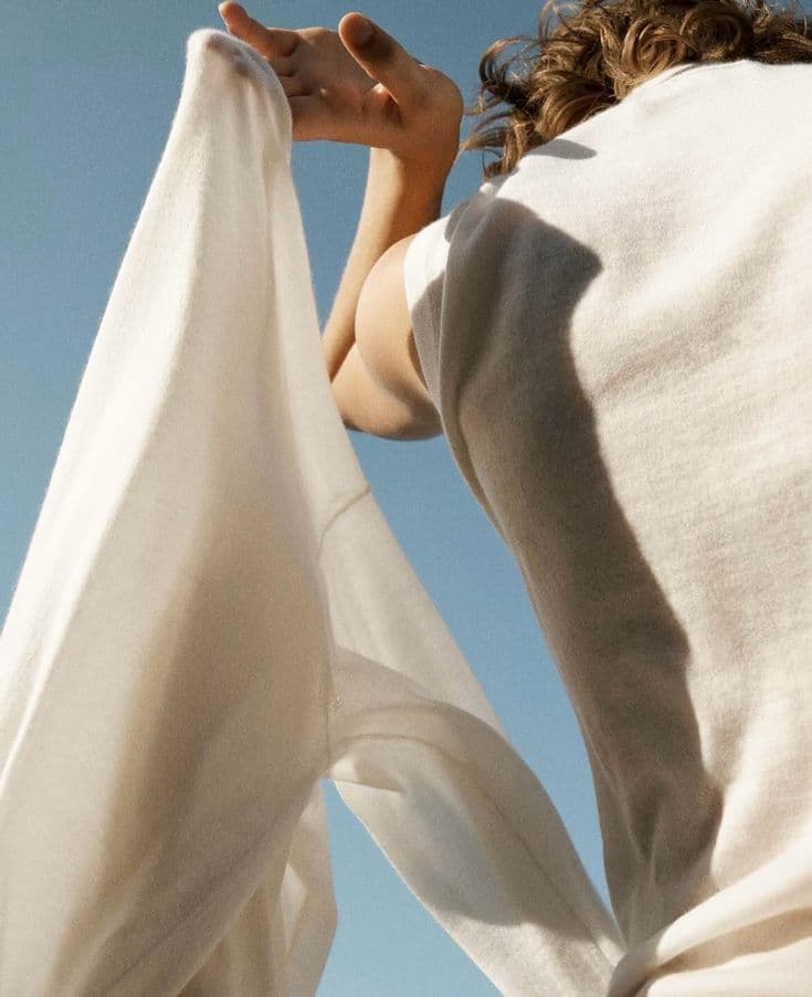 Cloth held up against an open sky, light passing through the weave
